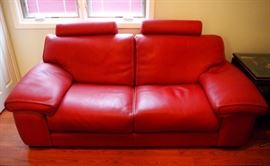 Lot 10: A Roche Bobois Ascot leather sofa. Upholstered in red European leather with contrast stitching, with two headrests, having a fir wood and poplar wood structure and beech base. Labeled: Roche Bobois. Nouveaux Classiques collection. Manufactured in Europe. 80" long. Very few minor creases to the leather; overall, good condition. ESTIMATE $ 2,000-3,000