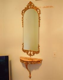 Lot 30: An Italian gilt metal mirror and wood wall-mounted console with marble top. A beveled glass mirror with arched top, fitted within a gilt metal frame. Together with a gilt wood demi lune console with beveled marble top. Good condition. Mirror, 49" high; console, 22 x 20" high. ESTIMATE $400-600