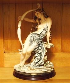 Lot 79: A Giuseppe Armani composition figure for Florence Sculpture d' Arte. Depicting "Diana", a seated nude with her arm around a bow, and an arrow at her feet. Signed "Giuseppe Armani" at the base. Mounted on a wood base, 14" high overall. Good condition. ESTIMATE $100-200