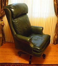 Lot 41: A Hancock & Moore leather upholstered desk chair. Dark green with brass nail head trim, on a swivel base with casters. Light creases and scratches to the leather due to use. 48" high. ESTIMATE $300-500