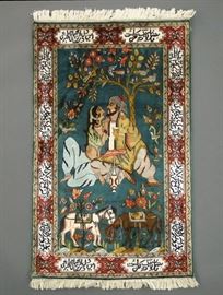 Lot 35: A 2.7 x 4.0 Indo-Persian silk pictorial rug. Depicting lovers seated beneath a tree in a garden setting, two horses below, on a teal ground with dark red border with cartouches enclosing poetry. Good condition. ESTIMATE $400-600