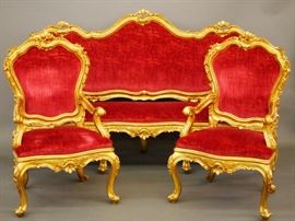 Lot 4: A four-piece Italian Rococo style parlor set. Including a settee, 82" long, and two armchairs, each having an upholstered back and seat flanked by open arms, together with a marble-top cocktail table. Hand carved gilded frames with foliate scrolls and rocaille, red velour upholstery. Very good condition, only slight wear. Table, 38 x 46 x 22 1/2" high. ESTIMATE $2,000-3,000