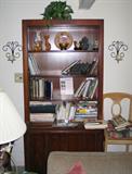 Bookcase, books, and wall sconces