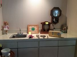 Old doll, golf signatures, Capodimonte flower, silver dresser set, vintage radio, 2 old clocks & a musical Anri Hummel wall item.