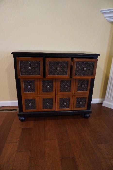 Storage cabinet with three small drawers on the top and the bottom opens to shelves inside