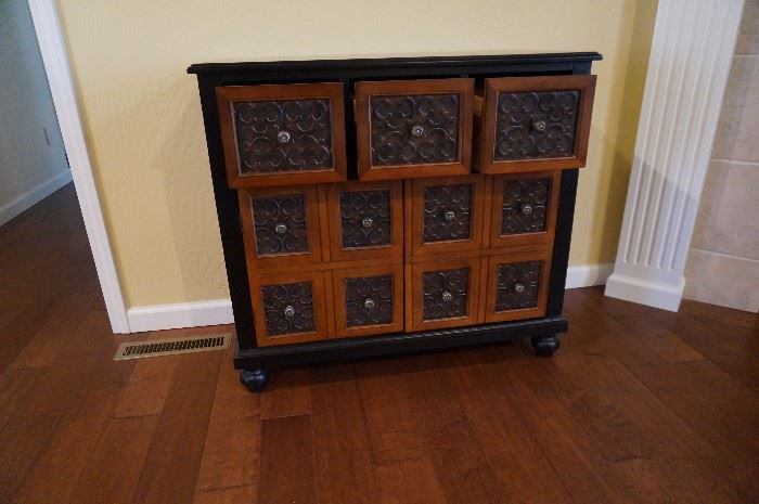 Storage cabinet with three small drawers on the top and the bottom opens to shelves inside