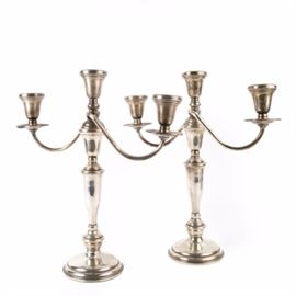 Preisner Weighted Sterling Silver Candelabras: A pair of Preisner weighted sterling silver candelabra. These candelabras support three taper candles. The fluted arms of the candelabra spiral away from the stemmed base. The candelabras can be screwed apart into three pieces that allow for four different sized candle sticks. The base is stamped “Preisner Sterling Weighted 834.”