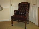Executive arm chair, on casters, covered in burgundy leatherette, have two