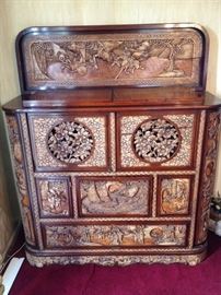 Elaborately carved cabinet with secret compartments and flip top bar. 