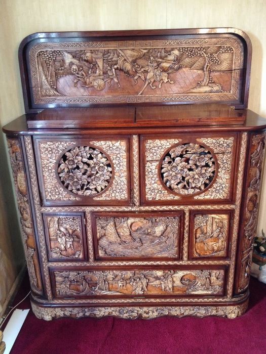 Elaborately carved cabinet with secret compartments and flip top bar. 