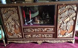 Elaborately carved Asian console with side cabinets and drawers. 