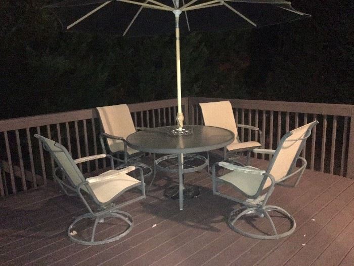 Patio table, 4-swivel arm chairs, umbrella and umbrella stand