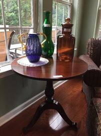 Assorted art glass pieces, round wood side table