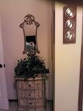 Entry table with matching mirror, floral arrangements.