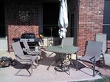 Patio set with umbrella, plants, outdoor statues, yard art, small patio plant holders and gardening tools.