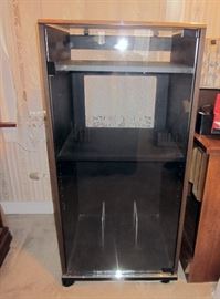 AKAI entertainment cabinet on casters.  Top turntable compartment, space for components and record album storage at bottom, glass front door and top.  19" wide, 18" deep, 40-1/2" tall.
