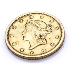 1851 Liberty $1 Gold Coin: An 1851 Liberty $1 gold coin. Designer: James Barton Longacre. Mintage: 3,317,671. Metal content: 90% gold, 10% copper. Diameter: 13 mm. Weight: 1.7 grams. Circulated. Good condition. There is some urethane or a similar substance on the reverse of the coin.