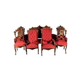 Antique Parlor Seating Set: An antique parlor seating set. This lot is made up of seven items. There are six chairs and a settee. The four matching chairs feature elaborate carving to the wooden frames, pierced back splats, red upholstered seats, and cabriole legs. The two armchairs feature tufted back cushions, upholstery on the arm post, and wooden carving along the bottom and top rails. The settee features two arm posts, tufted red upholstery, elaborate carving on the top rail of the wood, scroll feet.
