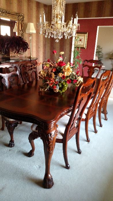 This is a large table with 2 leaves and table pads. Table shown with one leaf. There are 2 arm chairs and 6 regular chairs.
