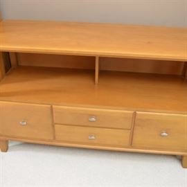 Ethan Allen Maple TV Stand: An Ethan Allen TV stand in maple. The unit has an open shelf under the top over four drawers with nickel pulls. There is a deep drawer on each side and two half depth drawers in the middle. The modern design features straight lines with nickle hardware on the drawers and sits on four short tapered legs.