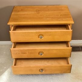 Ethan Allen Maple Night Stand: An Ethan Allen nightstand in maple. The unit has three equal sized drawers. The modern design features straight lines with nickel hardware on the door and sits on four short tapered legs.