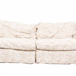 Sofa Express Upholstered Sofa with Floral Fabric: A Sofa Express upholstered sofa with tan fabric with cream colored foliate woven designs. The sofa has two removable seat cushions and two removable back cushions.