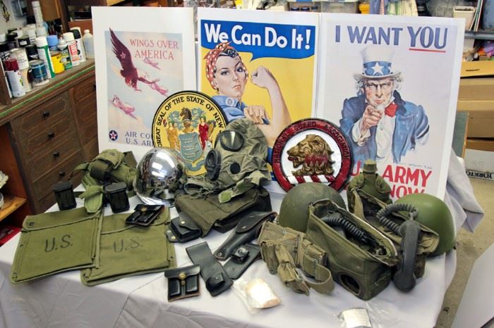 WWII era posters / misc military equipment to include: steel pot helmets, gas mask, map cases, and field phones / plaster bas reliefs of NJ State Seal and National Guard Association of NJ Carteret Lion logo