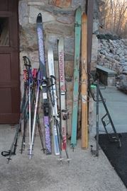 ski rack, skis and poles galore - some w/ vintage cable binding