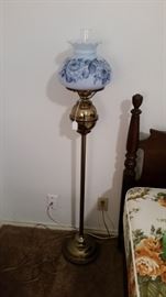 Brass floor lamp with globe glass shade.