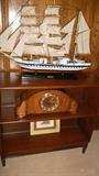 solid wood bookcase with mantle clock and model ship