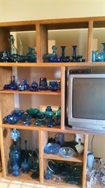 Turquoise glass displayed on oak wall unit. TV is also for sale.