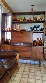 Lovely mid-century Danish modern room divider displaying several pieces of beautiful Carnival glass. Also shown: decorative glass in shades of brown, gold and orange.