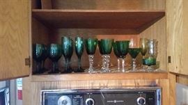 Multiples and one-of-a-kind green stemware, including champagne flutes and wine glasses.
