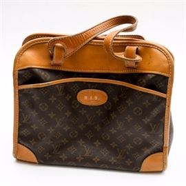 Vintage Louis Vuitton Carry-On Tote: A vintage Louis Vuitton carry-on travel tote. This bag features the signature monogram print coated canvas with aged Vachetta leather trim and brass tone hardware. The lined interior features divided sections and a “Louis Vuitton Licensed to The French Co.” label to the black fabric lining. A monogrammed “R.I.B.” badge is set to the front.