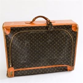Vintage Louis Vuitton Suitcase: A vintage Louis Vuitton Suitcase. This is a traditional Louis Vuitton piece in the iconic monogram print coated canvas with light brown leather accents, brass fixtures and some extra hardware inside. This bag has fabric interior and a tag marked, “Louis Vuitton Paris, France Manufactured by The French Co. USA Under Special License.” The suitcase also has Talon zippers, consistent with the Louis Vuitton bags circa the 1970s. There is a personalized monogram inside marked, “R.I.B.” The key to the exterior lock is not included.