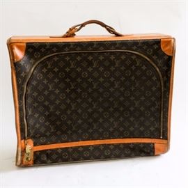 Louis Vuitton Suitcase: A vintage Louis Vuitton suitcase in the iconic dark brown monogram print coated canvas with tan leather accents and gold tone hardware. The suitcase offers a leather handle, a personalized monogram to the top, a modern Louis Vuitton garment bag and two organizational side pockets.