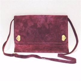 Salvatore Ferragamo Suede Handbag: A Salvatore Ferragamo violet suede handbag. This richly colored handbag features gold tone hardware, an adjustable shoulder strap and an interior zipper pocket. An interior leather tab is marked, “Salvatore Ferragamo P21-6629 Made in Italy.”