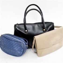 Collection of Italian Made Handbags Including Ferragamo: A collection of Italian made handbags including Ferragamo. This grouping of three includes a black zippered top vintage Salvatore Ferragamo tote bag, along with a woven blue leather pouch style bag by Saks Fifth Avenue. Also included is an ivory leather envelope style bag with a matching leather shoulder strap marked “Made in Italy” to the interior.