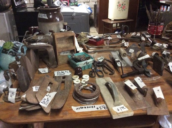 Entire table of vintage tools, planers, sad irons, plow points, ice tongs, bolt cutters. Too much to list. Craft table that disassembles for storage.