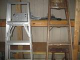several aluminum and wooden ladders