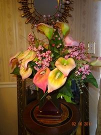 A beautiful arrangement of artificial flowers with wooden vase as a decor piece.