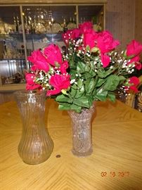 Beautiful glass vases, one with artificial red roses.