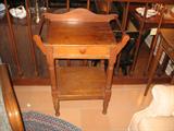 A cute small washstand with towel racks on each side