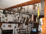 A brick wall in the family room full of antique tools, and unique collectibles