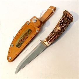 German Carved Natural Stag Handle 3" Fixed Blade Vintage Knife: A German carved natural antler handle 3" fixed blade vintage knife with leather sheath. Knife features a carved 12-point stage likeness on the natural stag horn base handle, a brass guard, and normal shaped steel blade that is stamped “Rostfrei Solingen” on one side. The leather sheath has stitched seams and rivets for strengthening. Top of blade casing has a color screen print of the German mountain valley village “Berchtesgaden” with the name printed at the skyline. Berchtesgaden is a municipality in the German Bavarian Alps located in the south district of Bavaria near the Austrian border.