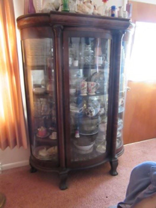 Oak curved glass china cabinet with carved paw feet.  
