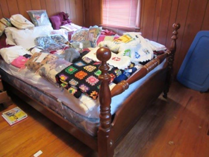 Queen size bed made by Drexel.   Mattress is in excellent shape. hand made granny square blanket is pictured as well as other linens. 