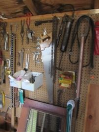 The outdoor tool shed has these tools as well as others not pictured. There are shovels, garden tools and ladder. 