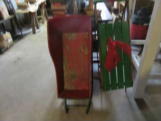 Early sled for a baby or child and another sled from the 50's painted for Christmas.