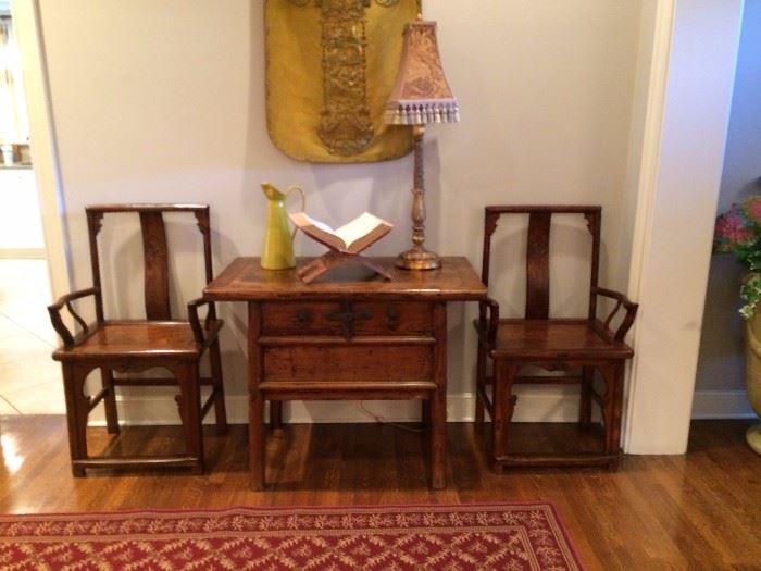area rug, lamp , wooden chairs and table with drawer